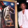 Fabian Perez standing next to Latin Grammy poster