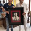 Julio Cesar Chavez standing next to portrait by Fabian Perez
