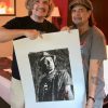 Phil Campbell standing next to portrait by Fabian Perez