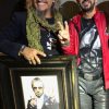 Ringo Starr standing next to portrait by Fabian Perez
