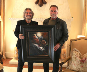 Arnold Schwarzenegger standing next to portrait by Fabian Perez
