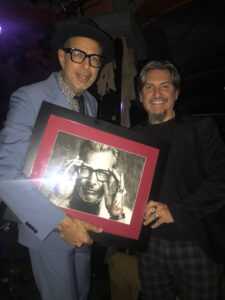 Jeff Goldblum standing next to portrait by Fabian Perez
