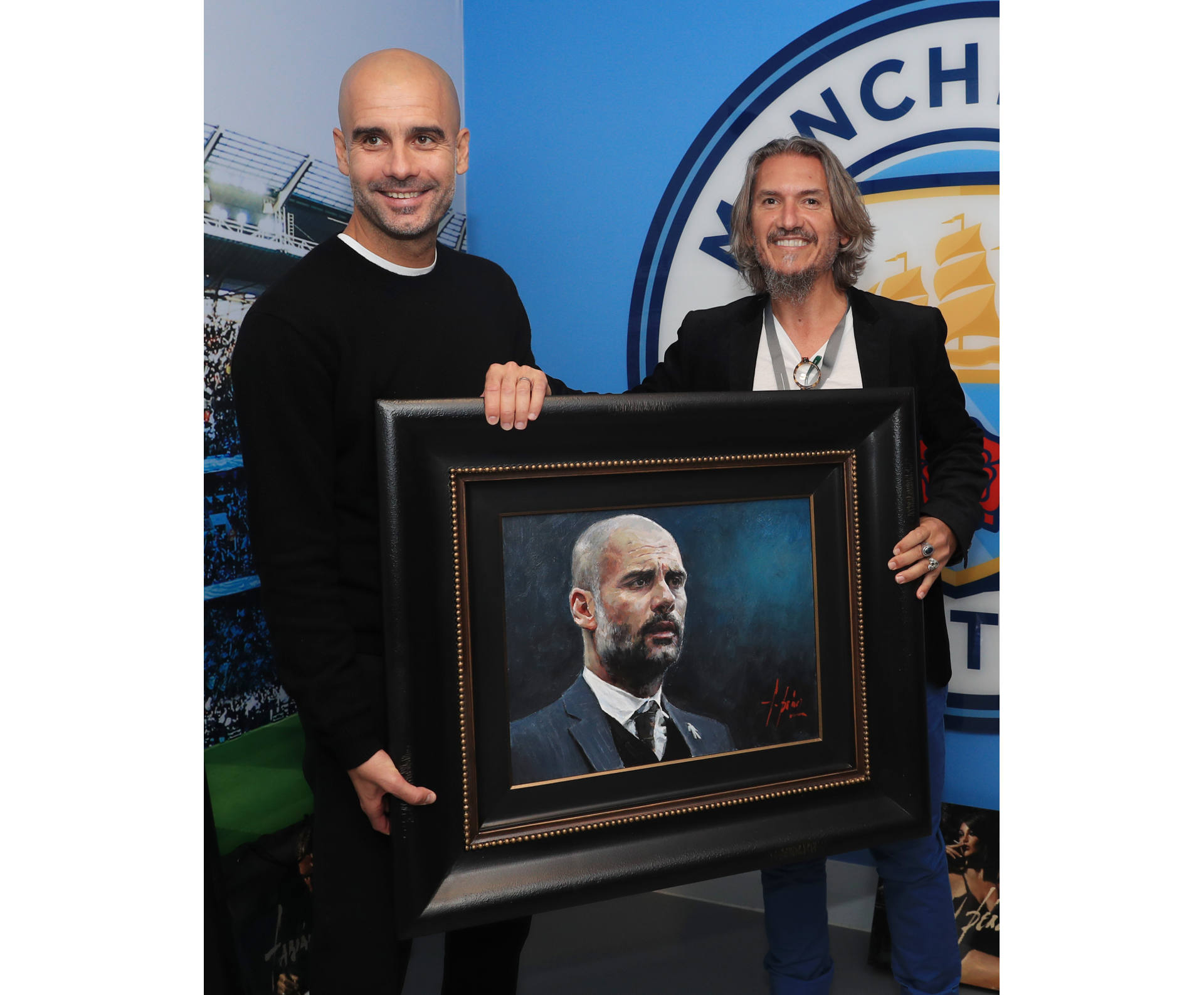 Pep Guardiola standing next to Fabian Perez holding portrait