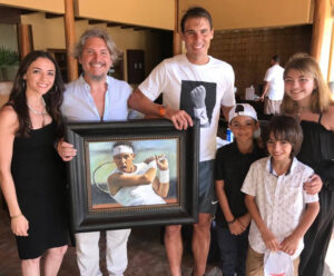 Rafael Nadal holding portrait alongside painter Fabian Perez and family