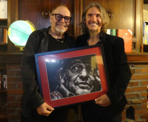 Vasco Rossi standing next to portrait by Fabian Perez